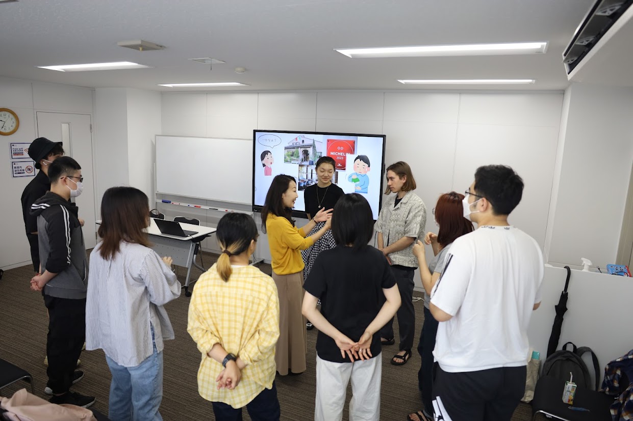 電子黒板にパワポを映し出しての授業。ペアワーク、グループワークがしやすいように、基本机を使わず授業を行っています。